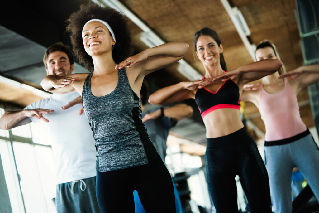 two women and a man exercising